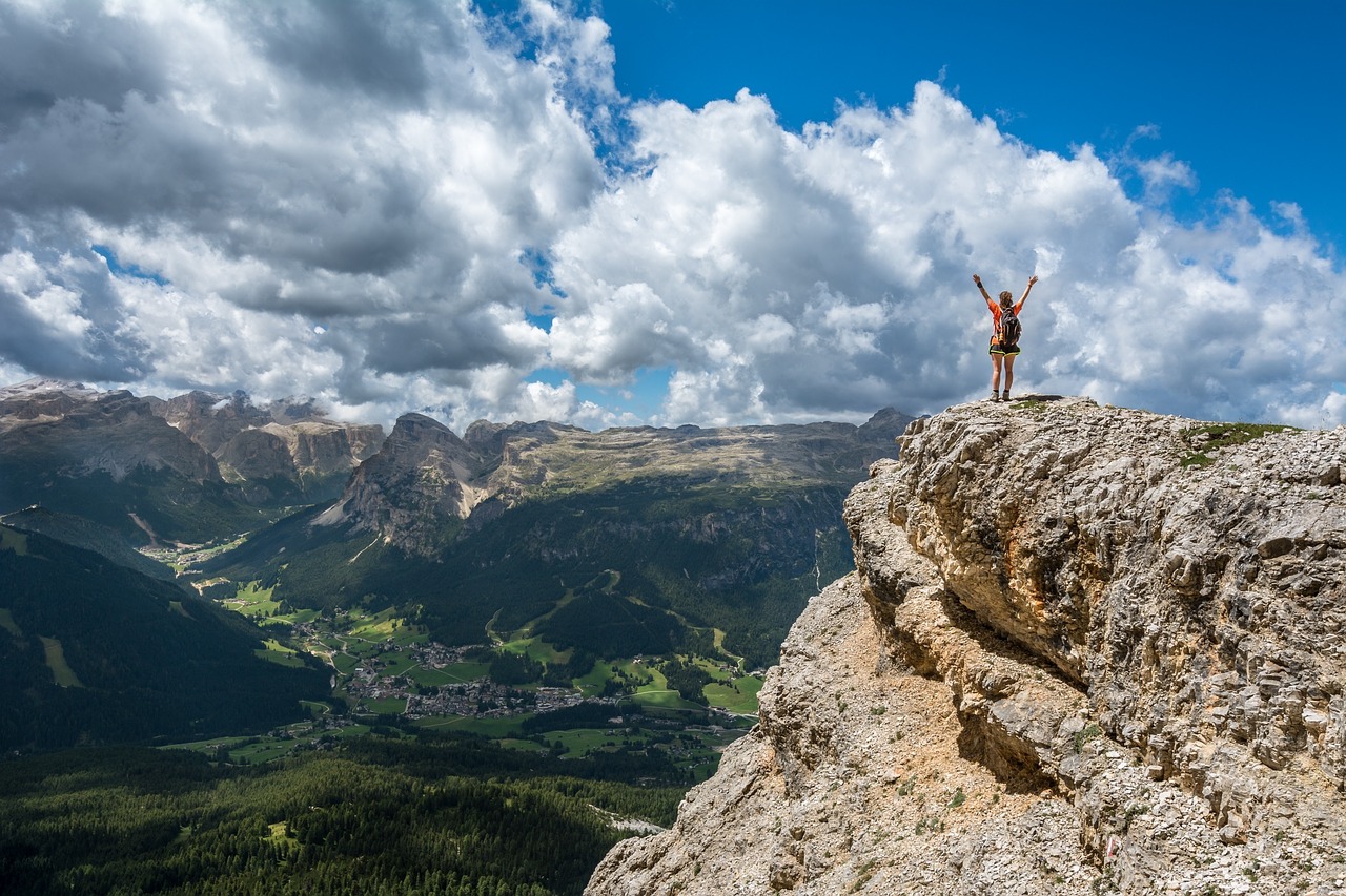 woman on mountain raised arms clouds job search